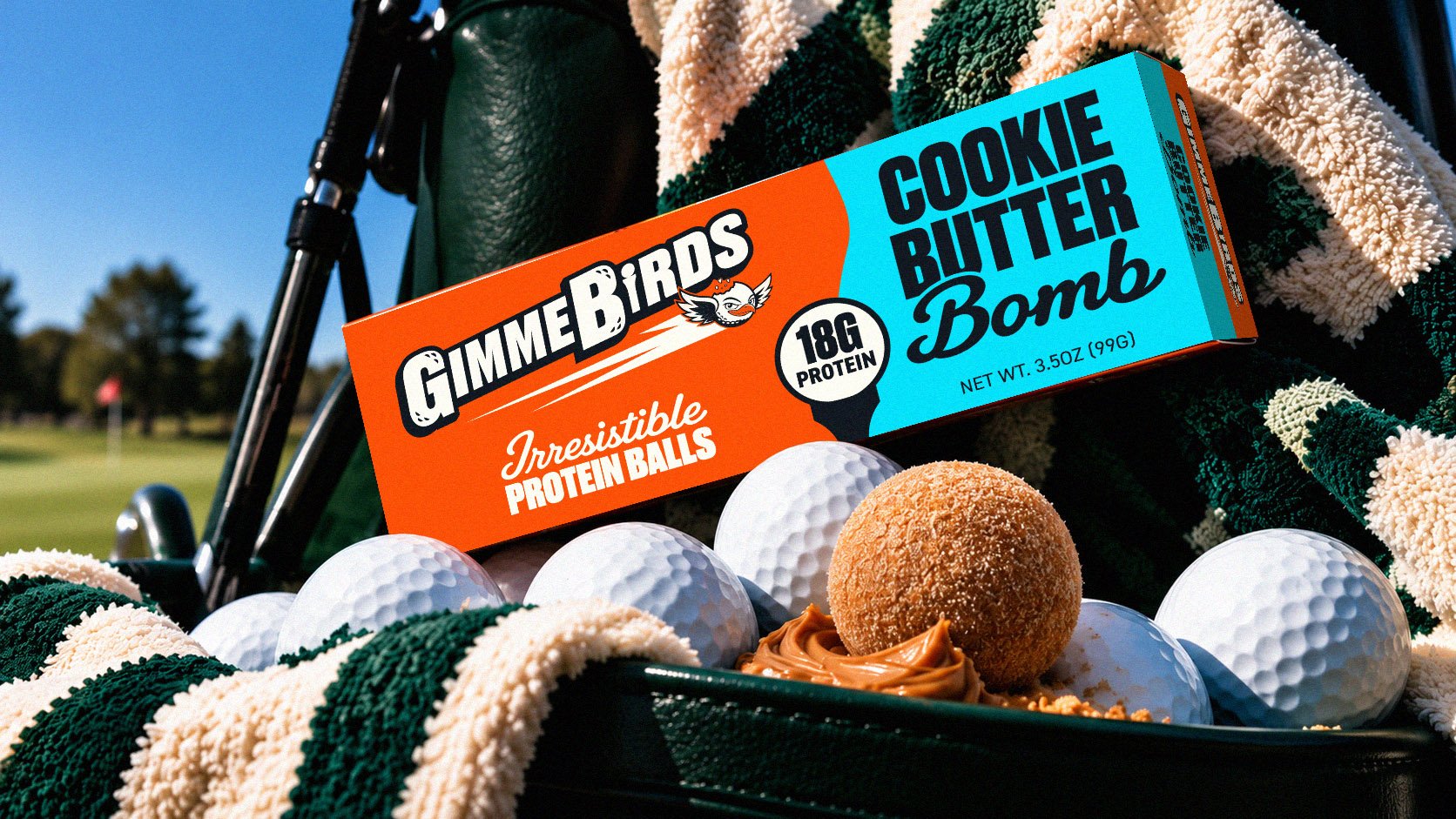 GimmeBirds Cookie Butter Bomb box resting on golf balls and a protein ball in a golf bag on the course
