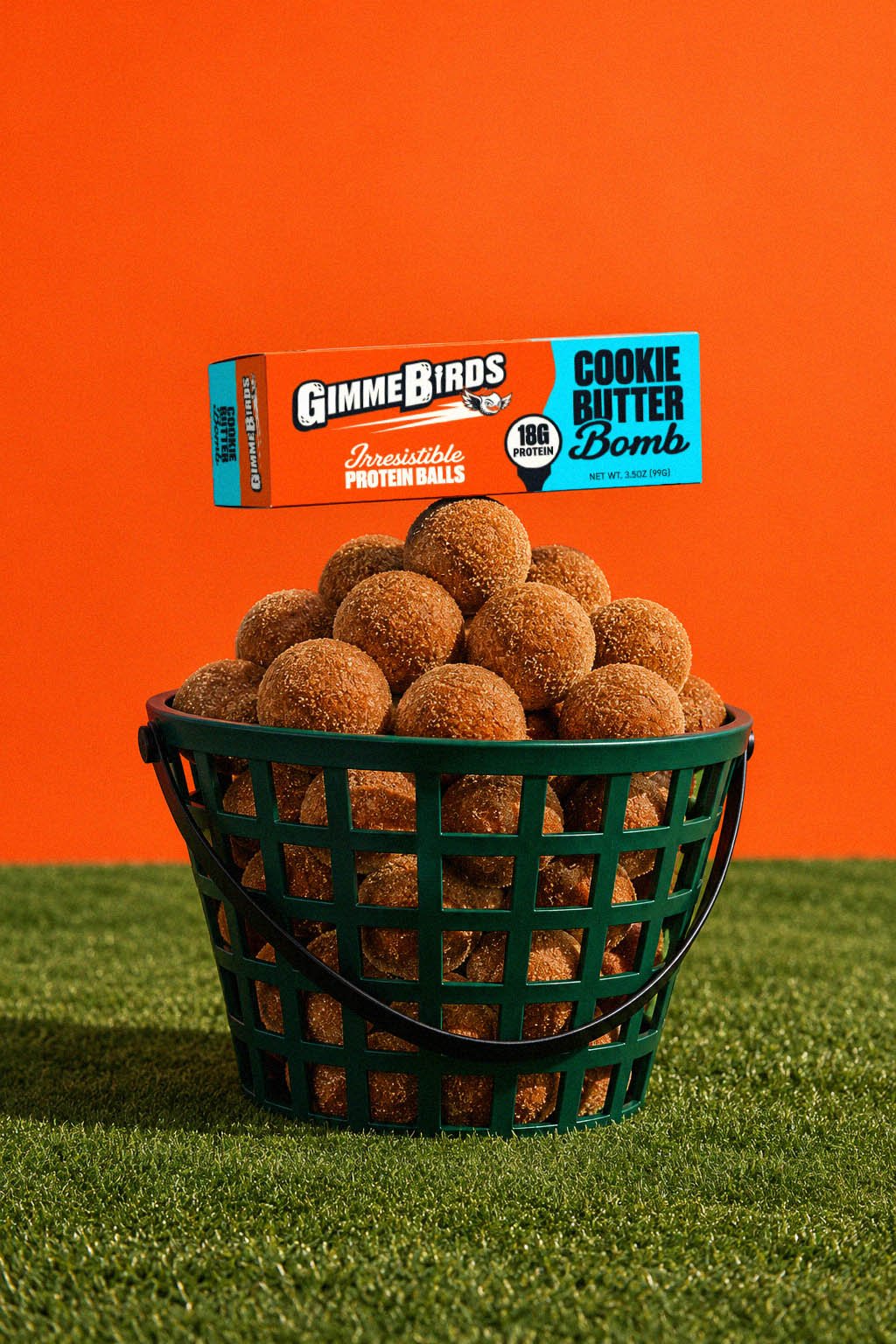 Range basket overflowing with GimmeBirds Cookie Butter Bomb protein balls, topped with the box